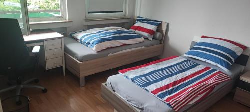 mała sypialnia z łóżkiem i biurkiem oraz łóżko sidx sidx sidx sidx w obiekcie Zum Flughafen w mieście Düsseldorf