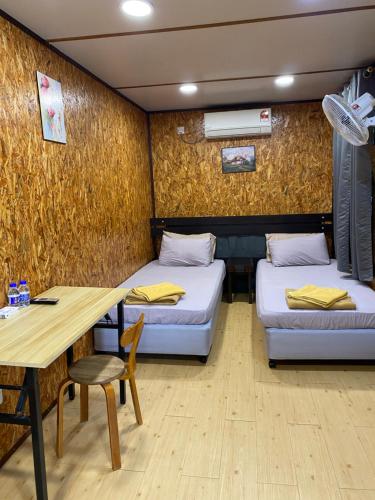 Zimmer mit 2 Betten, einem Schreibtisch und einem Tisch in der Unterkunft Igo Homestay Subang Airport in Shah Alam