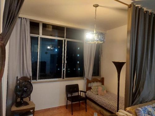 里約熱內盧的住宿－QUARTO EM COPACABANA，客厅设有窗户、沙发和椅子