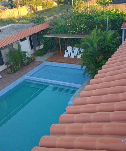 a swimming pool next to a villa with a house at Posada Casa Bonita in Puerto Maldonado