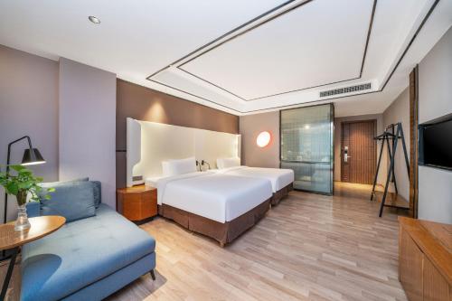 Ένα ή περισσότερα κρεβάτια σε δωμάτιο στο Campanile Shenzhen Gongming Honghuashan Metro Station