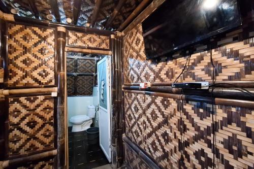 uma casa de banho com um WC num quarto com uma parede em RedDoorz at Kampung Istal Bogor em Jakarta