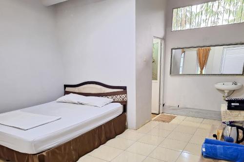 um quarto com uma cama, um lavatório e uma janela em RedDoorz at Kampung Istal Bogor em Jakarta