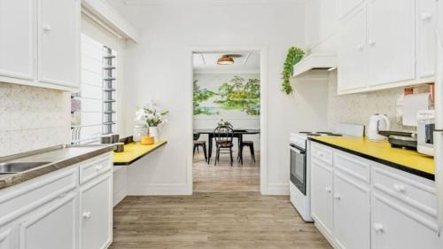 a kitchen with white cabinets and yellow counter tops at Scotts Cottage in Scotts Head