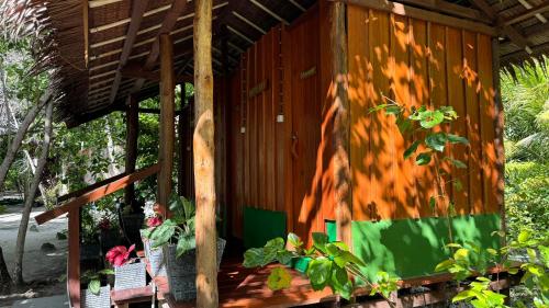 a wooden house with a wooden roof and some plants at Nyande Raja Ampat in Pulau Mansuar