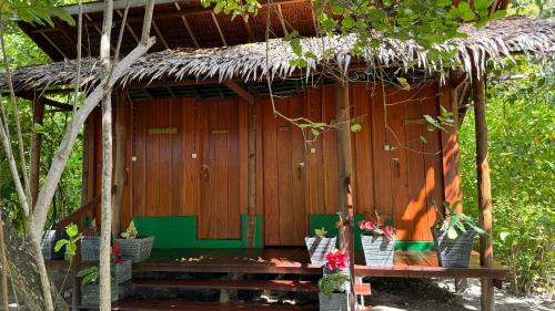 a hut with a bench in front of it at Nyande Raja Ampat in Pulau Mansuar