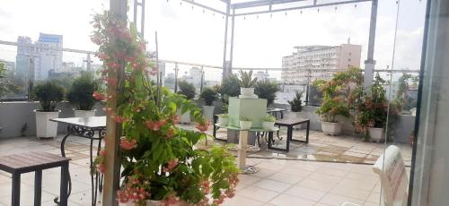 a patio with tables and potted plants in a building at C - Home in Can Tho