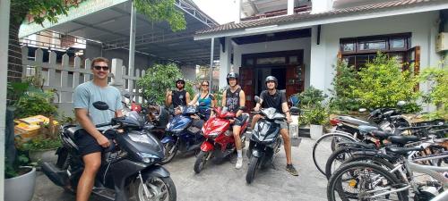a group of people sitting on motorcycles in front of a building at Melody Riverside Homestay in Thôn Trường Giang