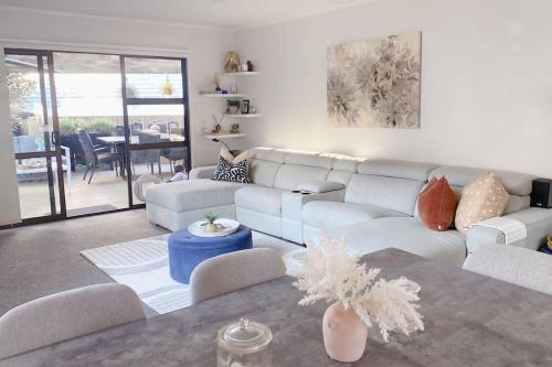 a living room with a white couch and a table at Ellerslie central in Auckland