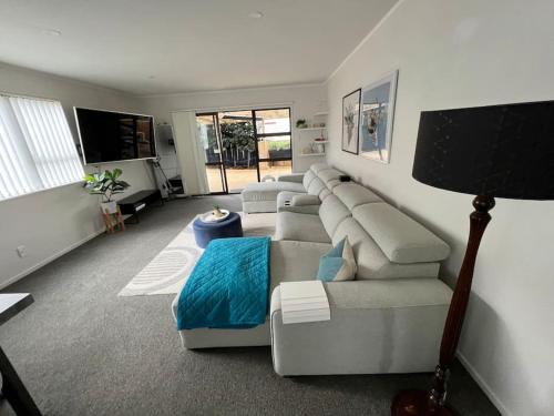 a living room with a couch and a tv at Ellerslie central in Auckland