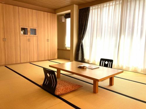 鳥取市にある観水庭 こぜにやのテーブルと椅子、窓が備わる客室です。