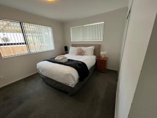 a bedroom with a bed and a window at Ellerslie central in Auckland