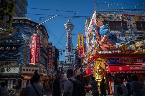 a crowd of people walking around a busy city street at Rakuyado Shinimamiya in Osaka