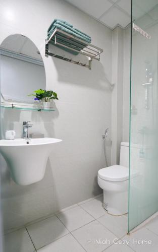 a bathroom with a sink and a toilet and a mirror at Niah Cozy Home - Train Street in Hanoi
