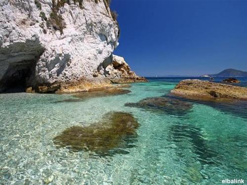 uma praia com água clara e uma grande rocha em Residence Capobianco em Portoferraio