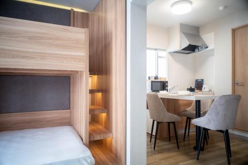 a small bedroom with a bed and a desk at Rakuyado Shinimamiya in Osaka