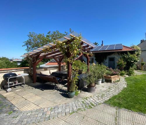 a pergola with a bench and a grill in a yard at Prvorepublikový dům se zahradou in Podivín