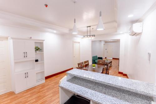 a kitchen and living room with white walls and a table at Santiago Cove Hotel and Restaurant in Santiago