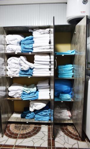 a closet with blue and white shirts and towels at Pyramids Temple Guest House in Cairo