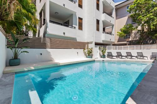 a swimming pool in front of a building at Bella Casa Noosa in Noosa Heads