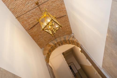 a chandelier hangs from the ceiling of a hallway at XX SETTEMBRE 69 in Trieste