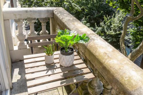 a wooden bench with two potted plants on a balcony at XX SETTEMBRE 69 in Trieste