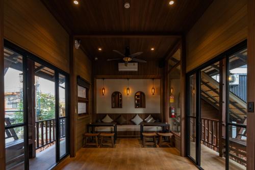 a living room with a couch and windows at Shamrock Chiangmai Hotel-Adult Only in Chiang Mai