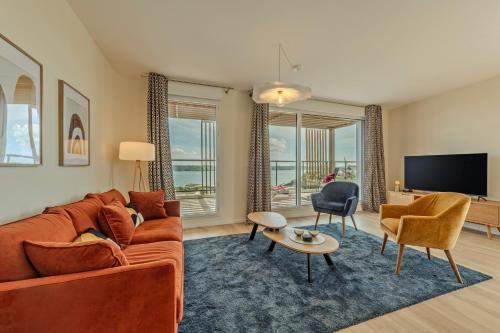 un salon avec un canapé et une télévision dans l'établissement Appartement standing vue mer imprenable, à Brest