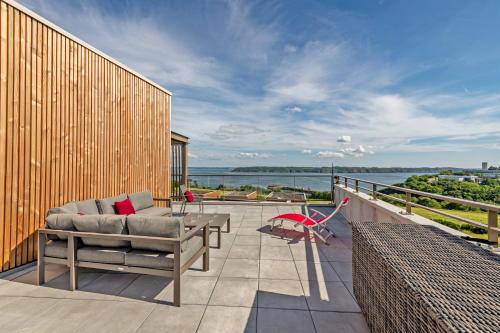 d'une terrasse avec un canapé et une table sur un balcon. dans l'établissement Appartement standing vue mer imprenable, à Brest