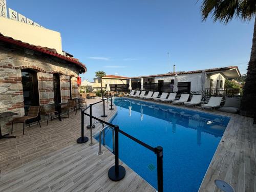 - une piscine avec des chaises à côté d'un bâtiment dans l'établissement Samel Hotel, à Siviri