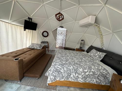 a bedroom with a large bed and a couch at Glamping El Encanto in Zapopan