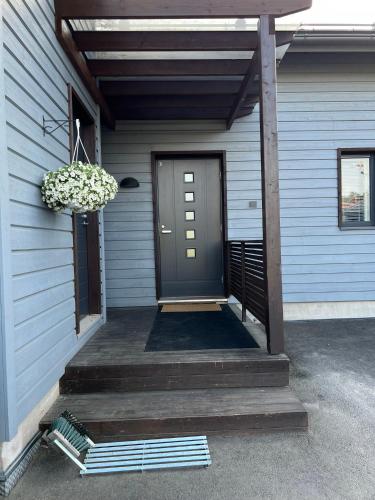 uma porta da frente de uma casa com um alpendre em Ihana huoneisto - The Nest with Sauna in VAASA em Vaasa