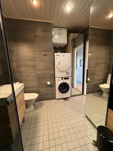uma casa de banho com máquina de lavar e secar roupa em Ihana huoneisto - The Nest with Sauna in VAASA em Vaasa