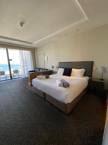 a hotel room with a large bed and a balcony at Ocean View Studio Apt - Surfer's Paradise in Gold Coast