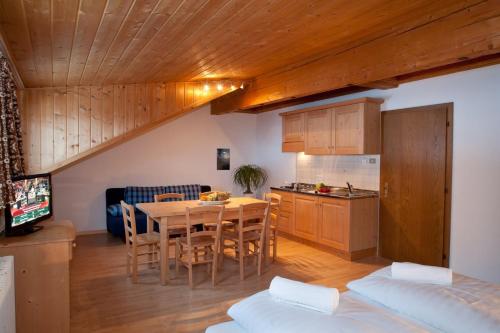 a kitchen and dining room with a table and chairs at Hotel Hofer in San Valentino alla Muta