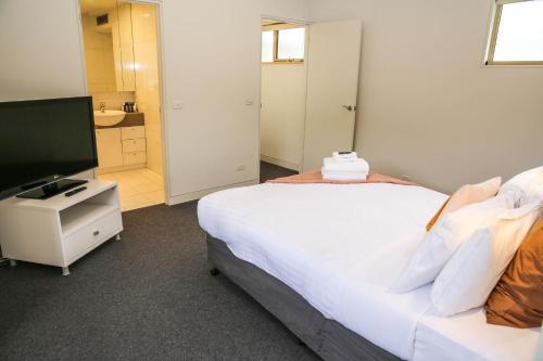 a bedroom with a bed and a flat screen tv at Wood Peak in Bright