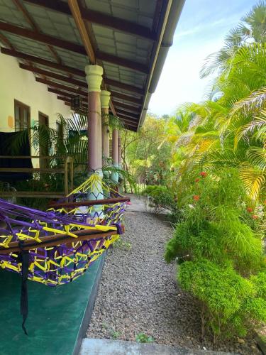 a patio with hammocks on a house with palm trees at Elena Garden Resort and Restaurant in Trincomalee