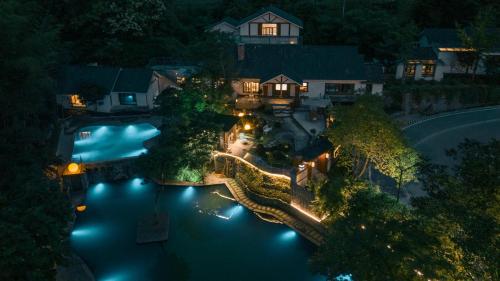 張家界市にあるFuxi-21 Homestayの夜間のスイミングプール付きの家の空中ビュー