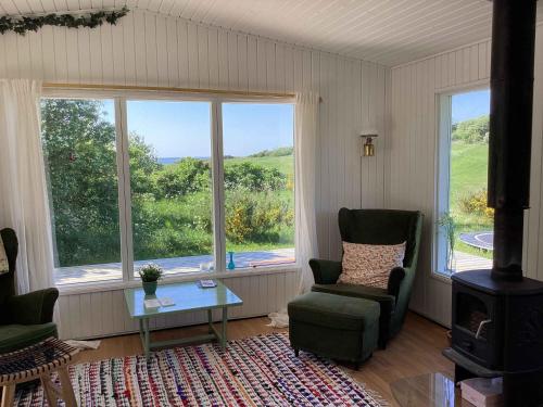 - un salon avec deux chaises, une table et des fenêtres dans l'établissement Peaceful, Idyllic Summerhouse, - Beach And Nature Sanctuary, à Spottrup