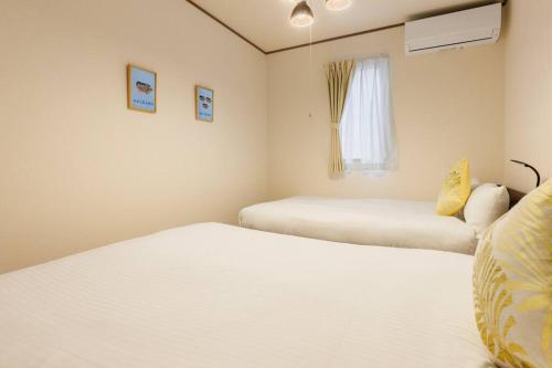 a bedroom with two beds and a window at LOA Chatan Resort in Chatan