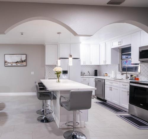 eine Küche mit weißen Schränken und einem Tisch mit Stühlen in der Unterkunft The pearl Island2 in Davenport