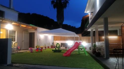 a backyard with a playground with a slide at Nikos Studios in Keri