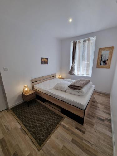 une chambre avec un grand lit avec une fenêtre dans l'établissement Les flocons enchantés t2 rdc neuf, à La Bourboule