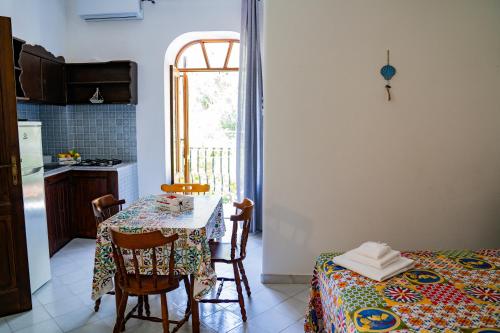 cocina con mesa, mesa y sillas en NIMA Holidays Home en Canneto
