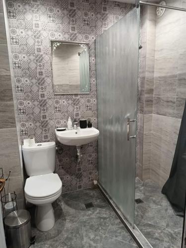 a bathroom with a toilet and a sink at Мезонет Мени - две спални и две бани in Burgas City
