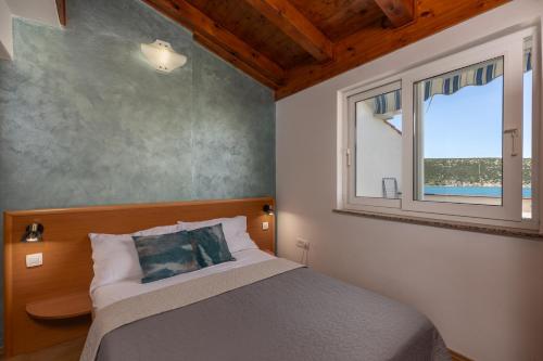a bedroom with a bed and a window at Family Resort Santa Maria in Stara Novalja