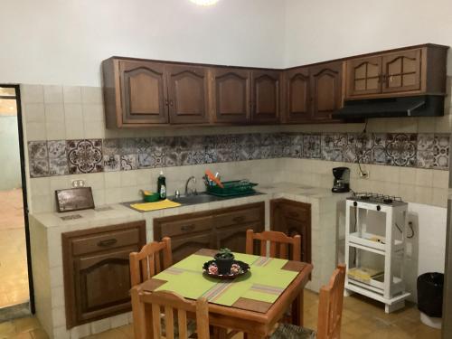 a kitchen with wooden cabinets and a table with chairs at La cueva in Tepic