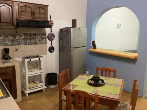 a kitchen with a table and a refrigerator at La cueva in Tepic