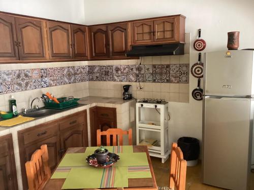 a kitchen with a table and a refrigerator at La cueva in Tepic