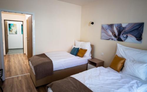 a hotel room with two beds and a mirror at Elixír Panzió in Nyírbátor